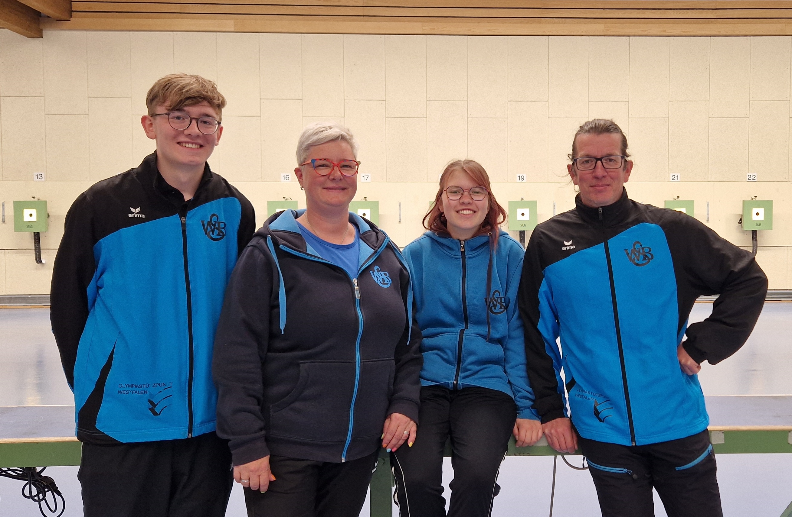 Vier Vereinsmitglieder in blauen Sportjacken mit ihren Auszeichnungen